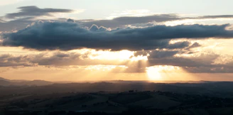 aerial view of mountains under cloudy sky during daytime