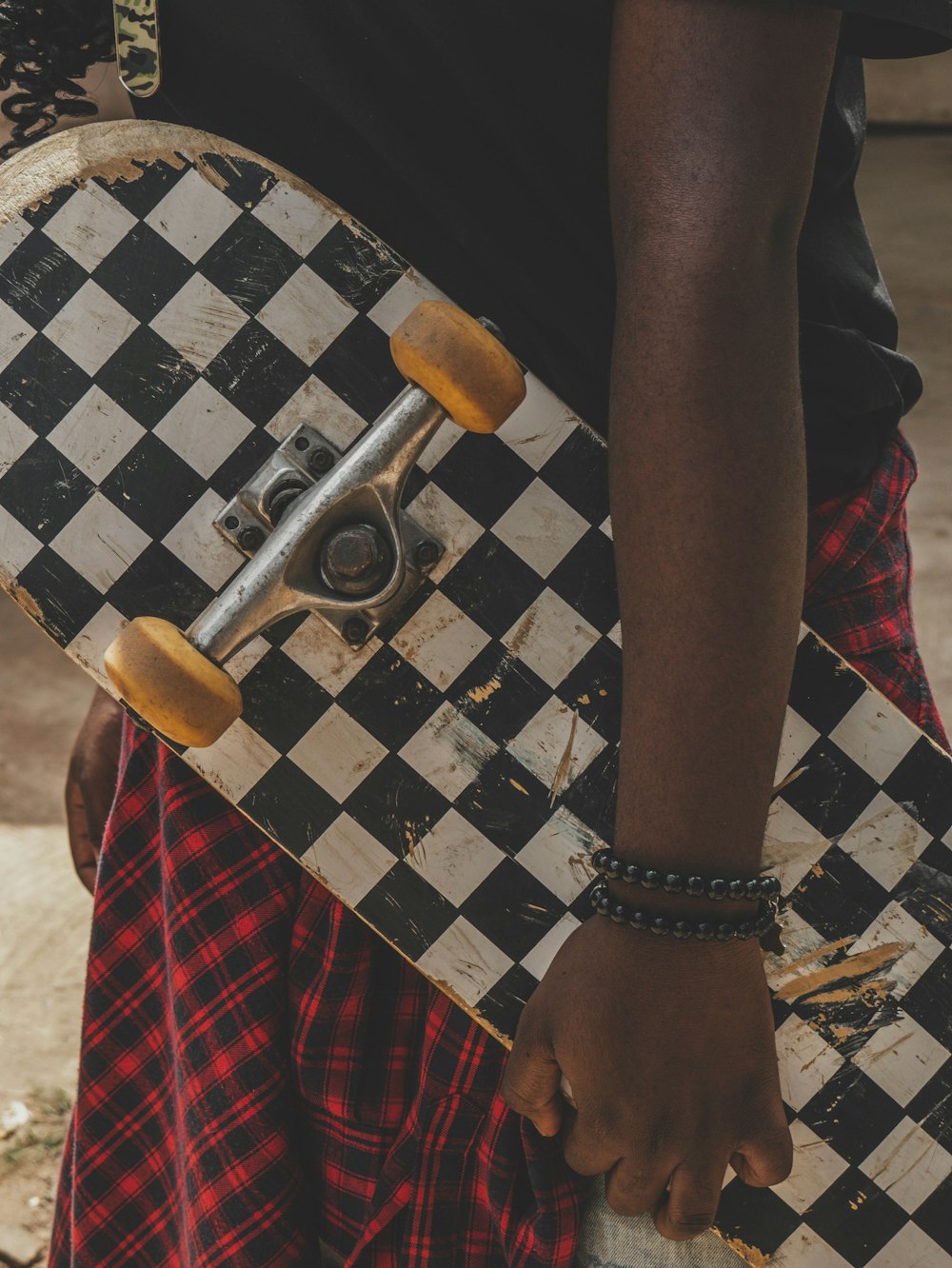 person in black and white checkered shorts standing on brown wooden seat