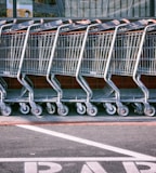 red and silver shopping cart on gray asphalt road during daytime