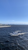 A powerful sport boat cutting through waves with Miami’s skyline in the background.