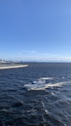 A powerful sport boat cutting through waves with Miami’s skyline in the background.