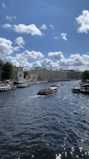 Tourists enjoying a felucca ride on the Nile River near lush green banks under a clear blue sky.