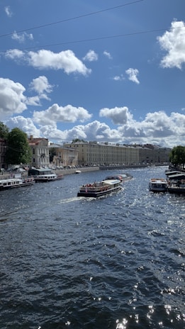 Tourists enjoying a felucca ride on the Nile River near lush green banks under a clear blue sky.