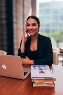 A friendly consultant smiling while talking on the phone in a cozy office.