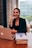 Close-up of a satisfied client smiling while discussing business on a laptop.