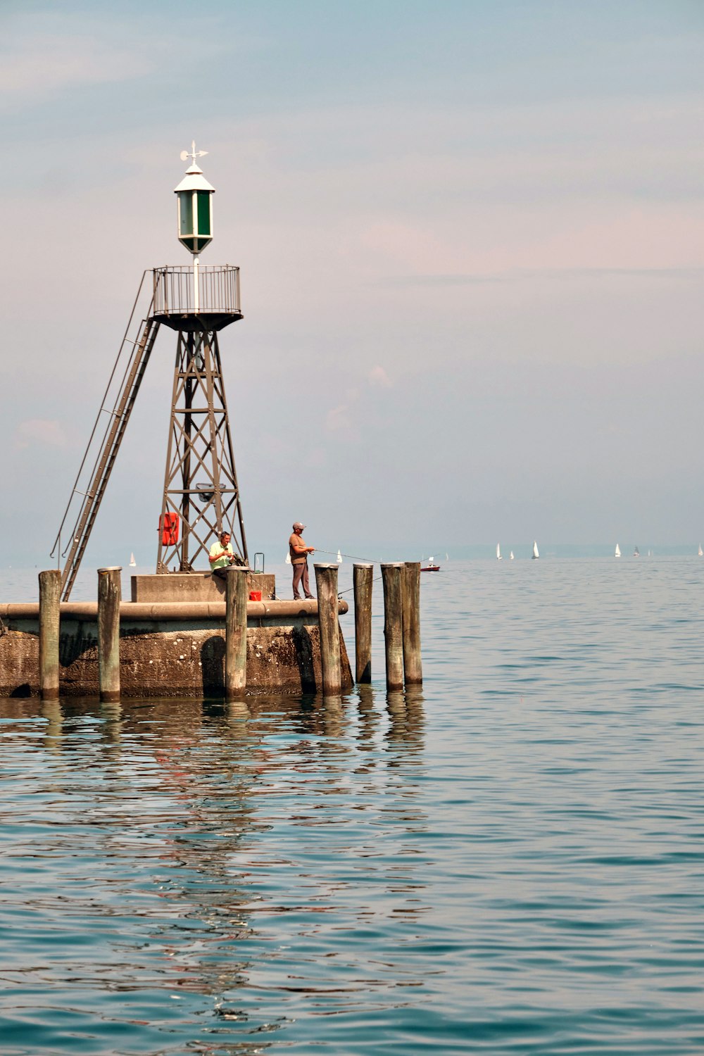 white and black lighthouse on brown wooden dock during daytime