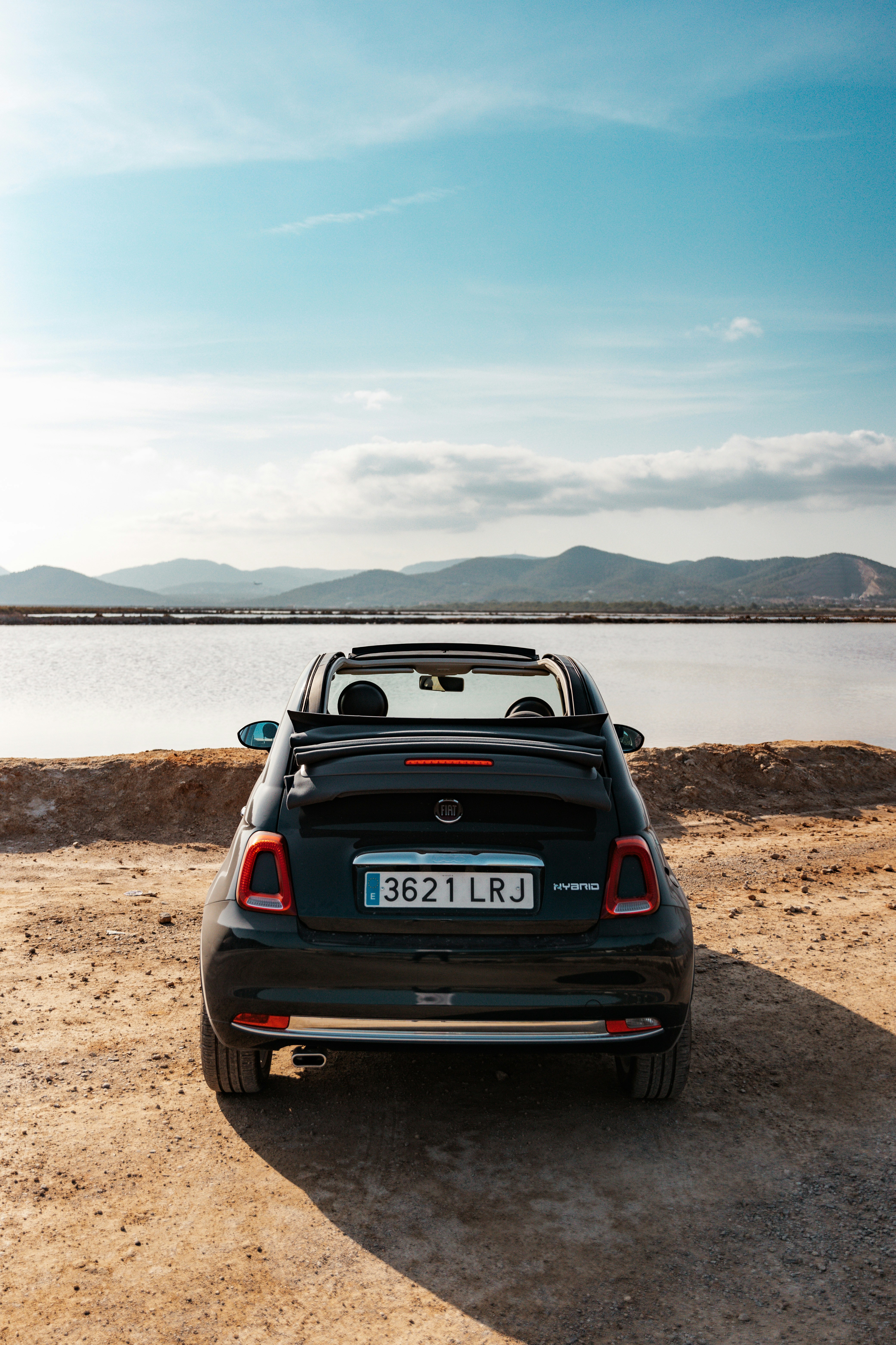 black fiat 500 on ibiza's beach shore during daytime