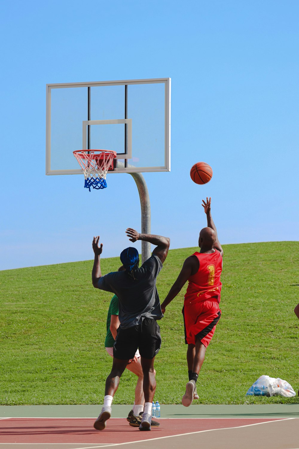 4 men playing basketball on green grass field during daytime