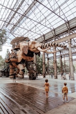 people walking on sidewalk near elephant statues