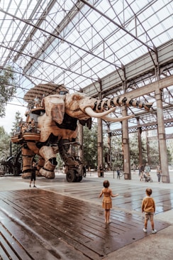 des gens marchant sur le trottoir près des statues d'éléphants