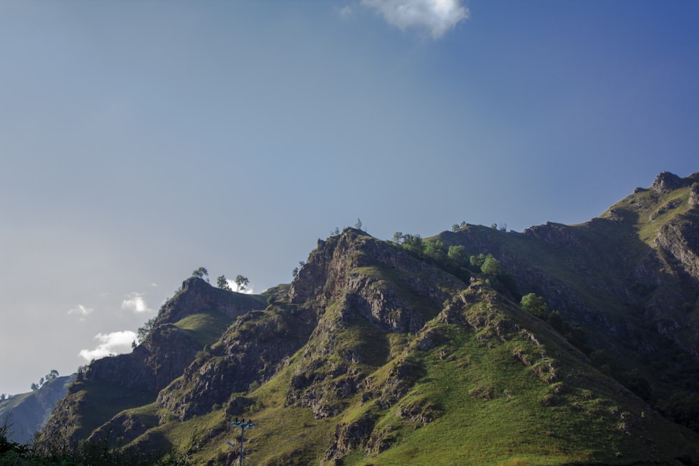 Montaña verde y marrón bajo el cielo azul durante el día