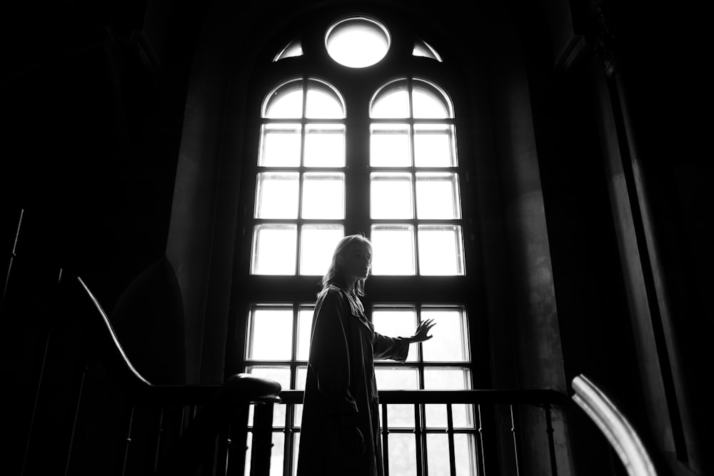 woman in white dress standing on window