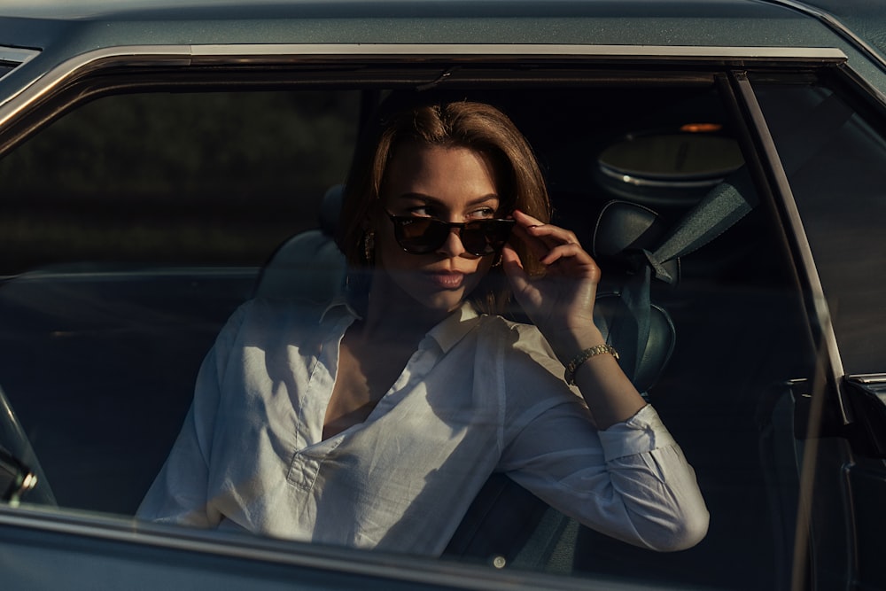 woman in white dress shirt wearing black sunglasses