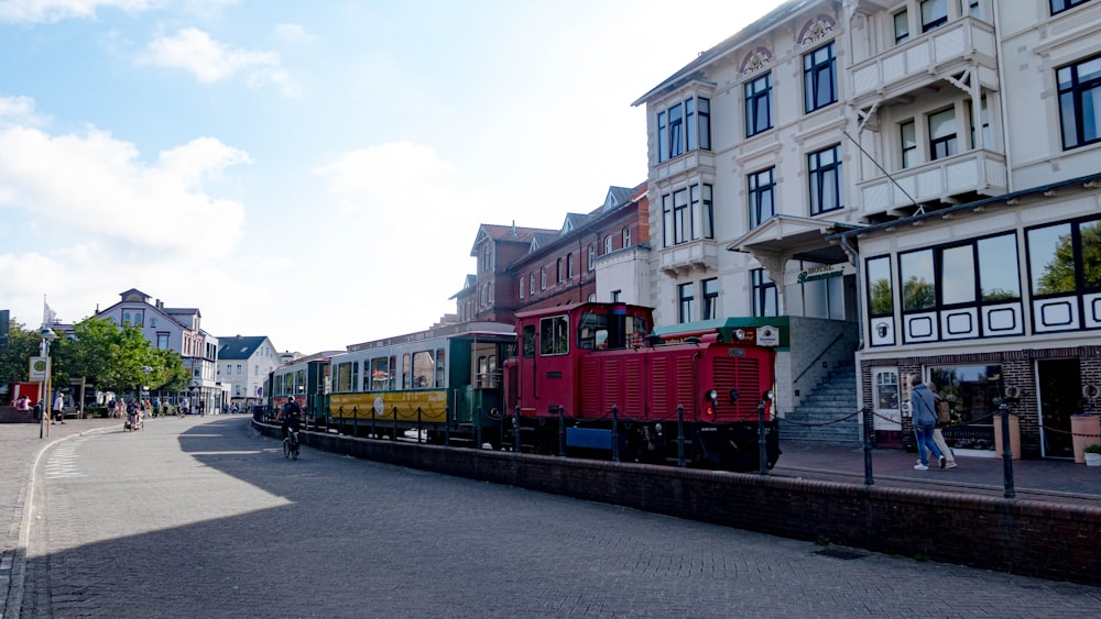 red train on rail road near building during daytime