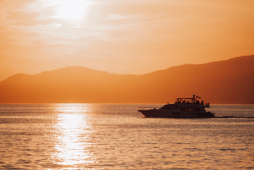 silhouette of ship on sea during sunset