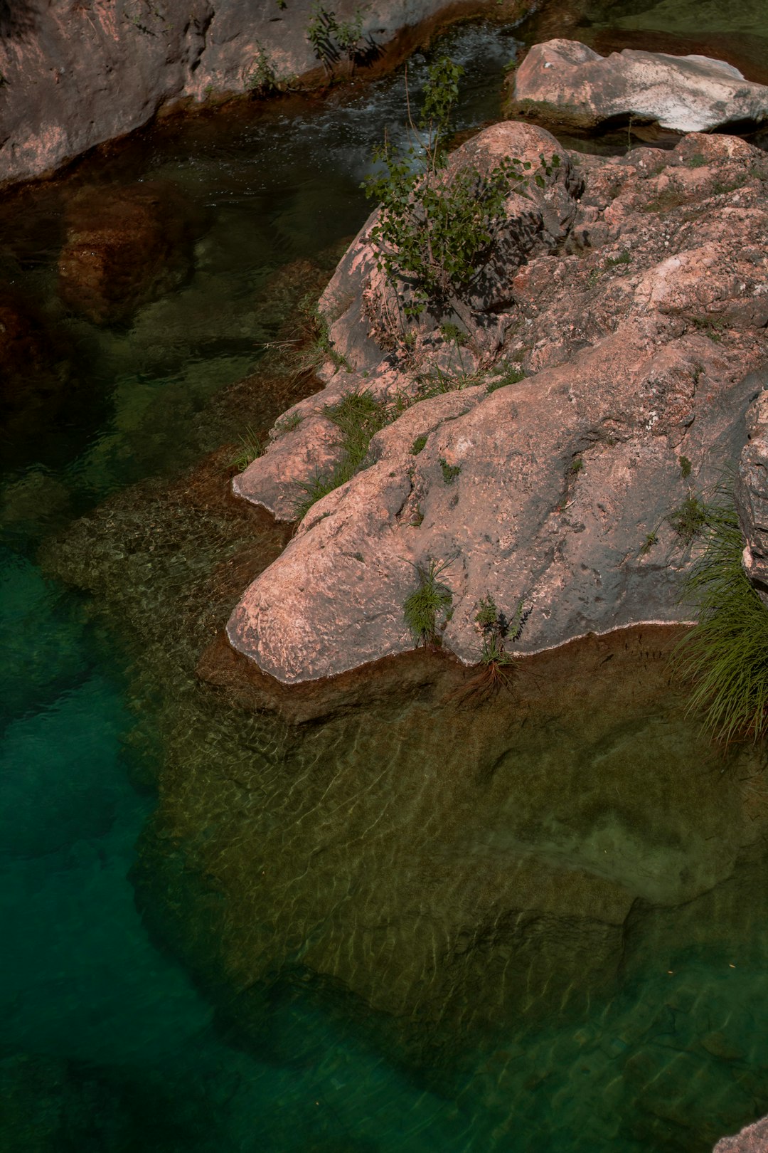 brown rock formation beside body of water during daytime