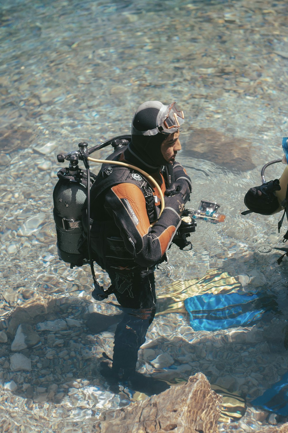 2 men in black and red wet suit holding black and red helmet