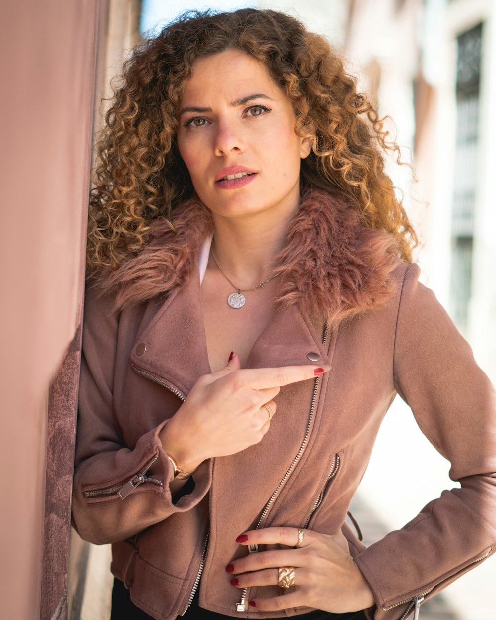 woman in brown coat holding brown leather handbag