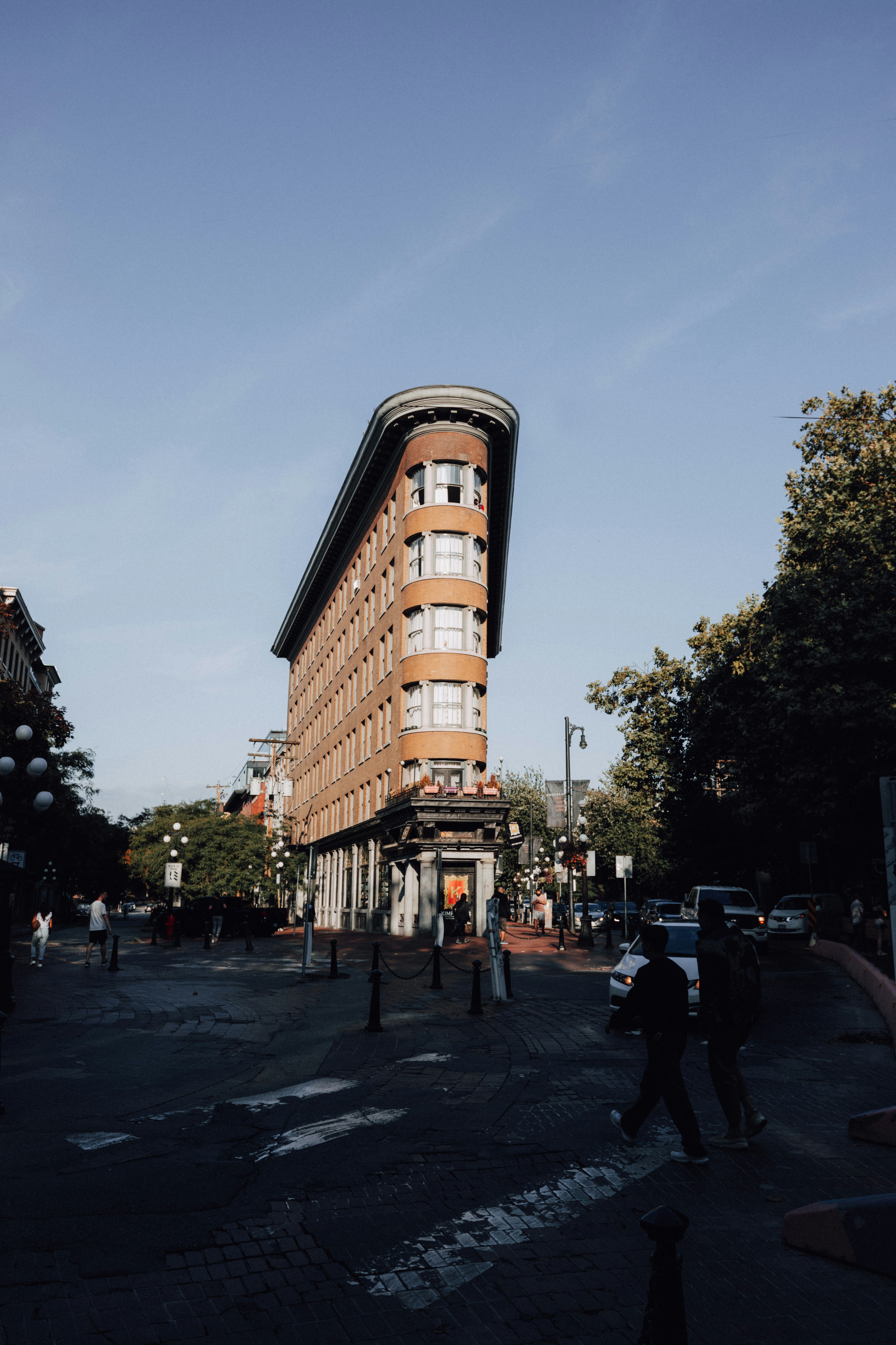 people walking on sidewalk near brown concrete building during daytime