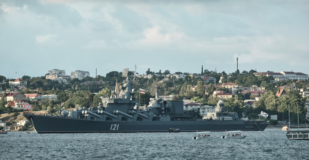 black ship on sea under white clouds during daytime