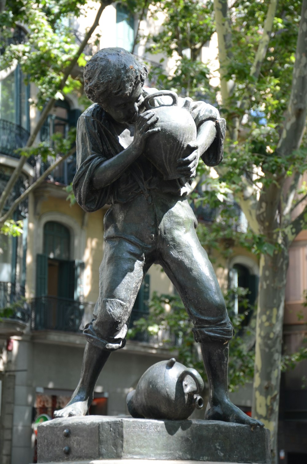 man in black jacket and pants holding a baby statue