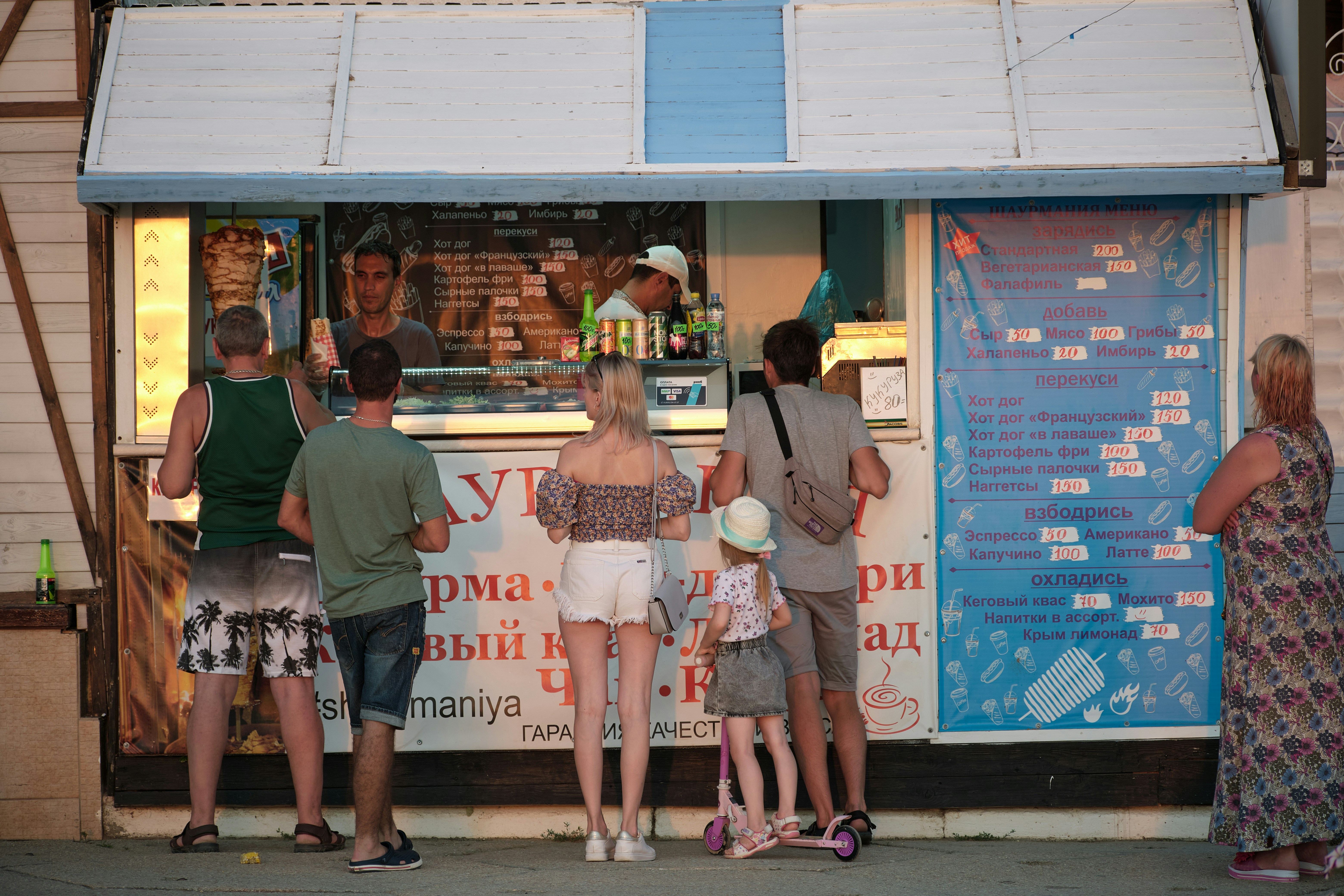 woman in white and pink floral dress standing beside woman in green shirt