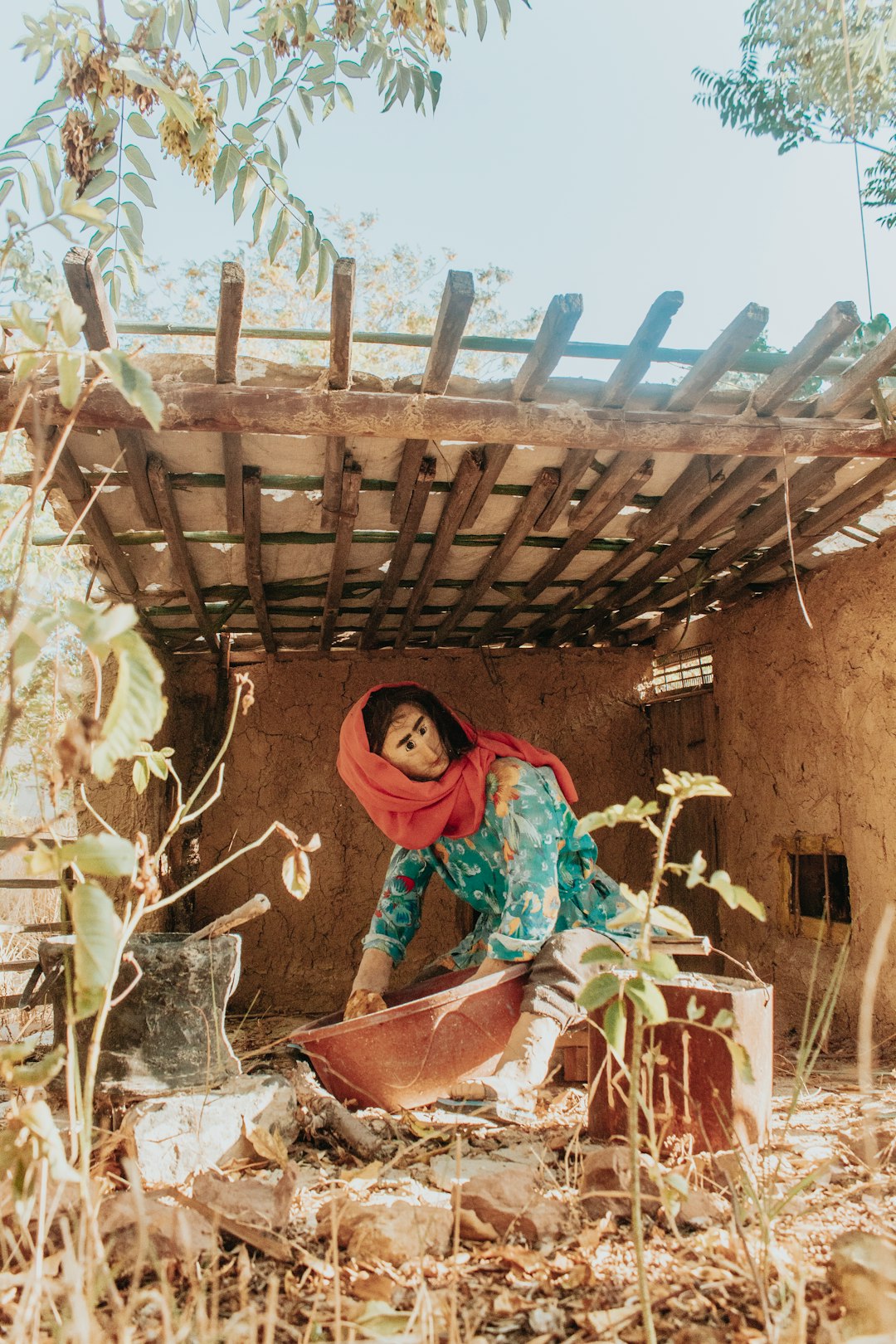 woman in green and red hijab sitting on brown wooden chair