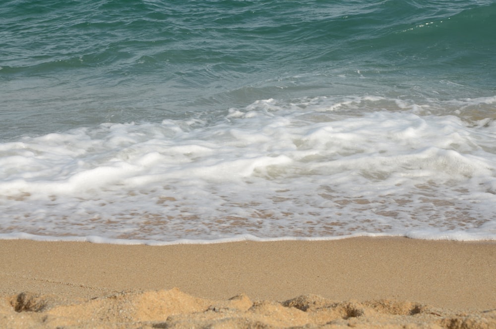 sea waves crashing on shore during daytime