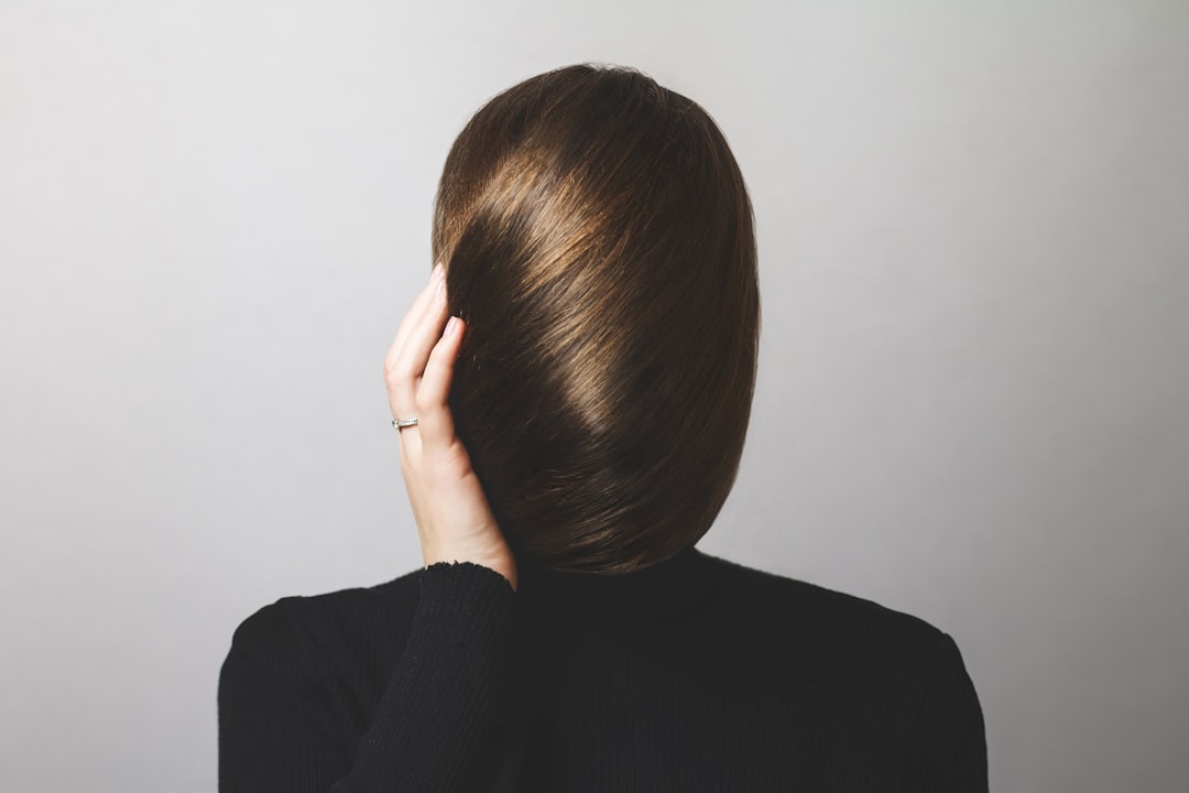 woman in black long sleeve shirt covering her face