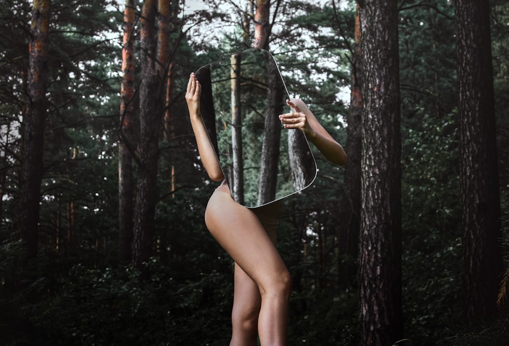 woman in black bikini standing on forest