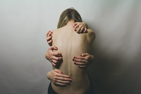 bareback woman, hands scratching at her from all directions, depicting trauma triggers