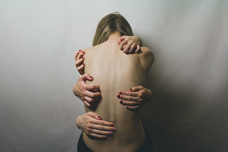 woman in black tank top covering her face