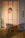 Close-up of a round rattan table leg cap installed on a wooden table leg in a cozy living room.
