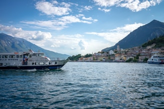 A scenic view of the ocean with a ferry in the foreground.