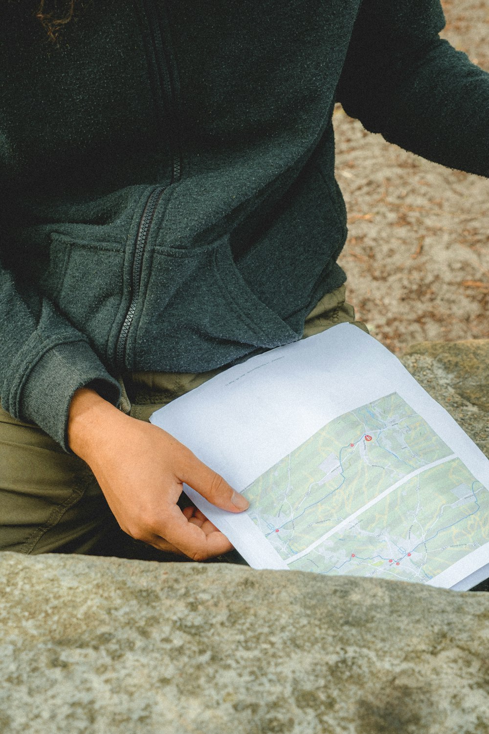 person in black denim jeans holding white paper