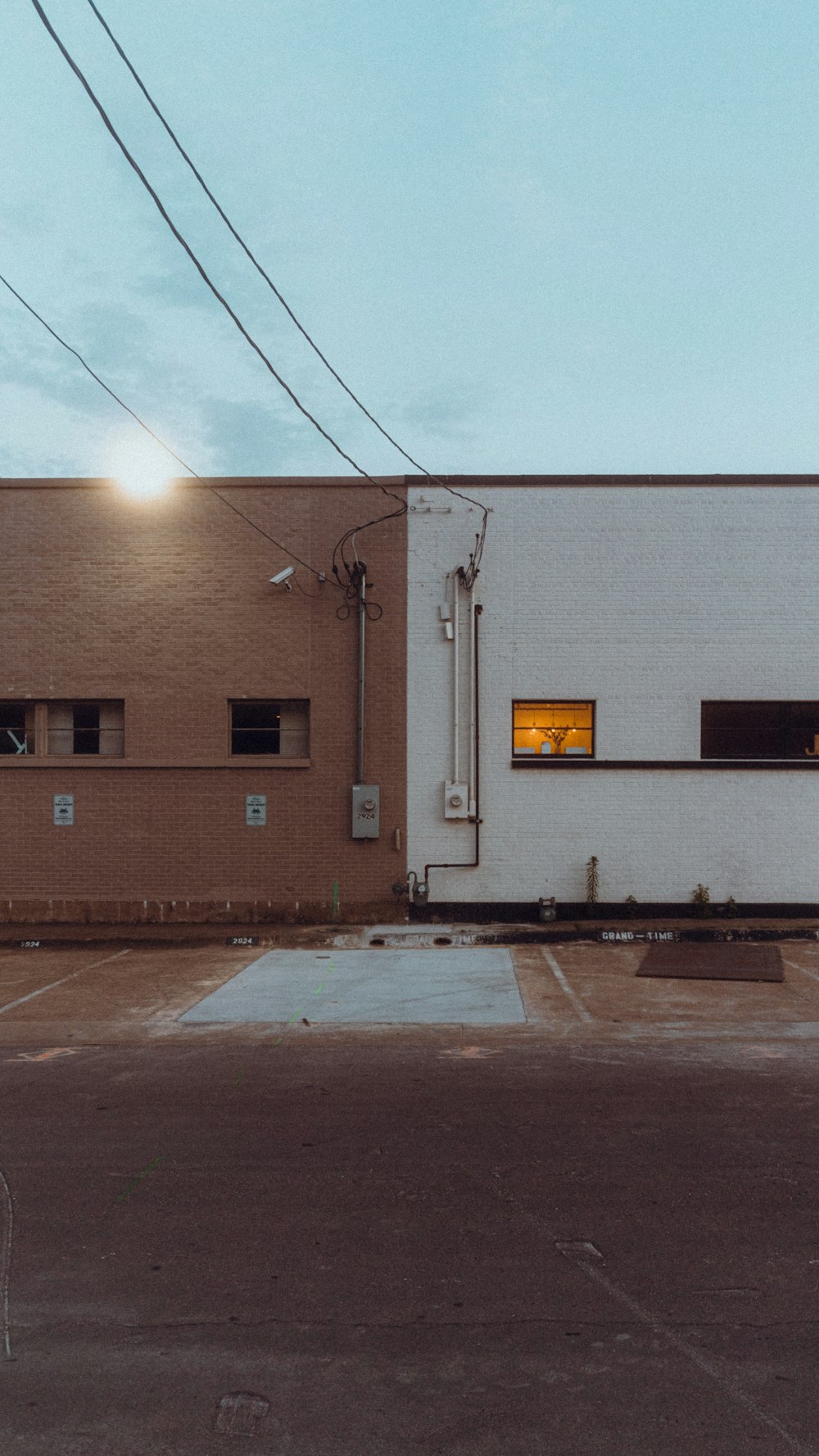 an empty parking lot with a building in the background