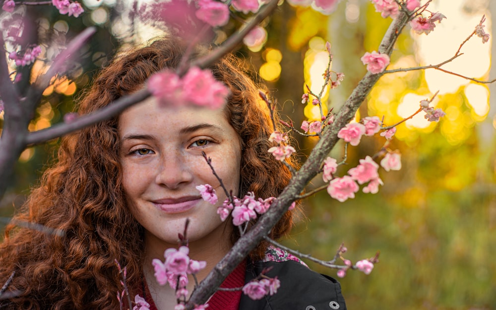 woman in black coat with pink flowers on her head