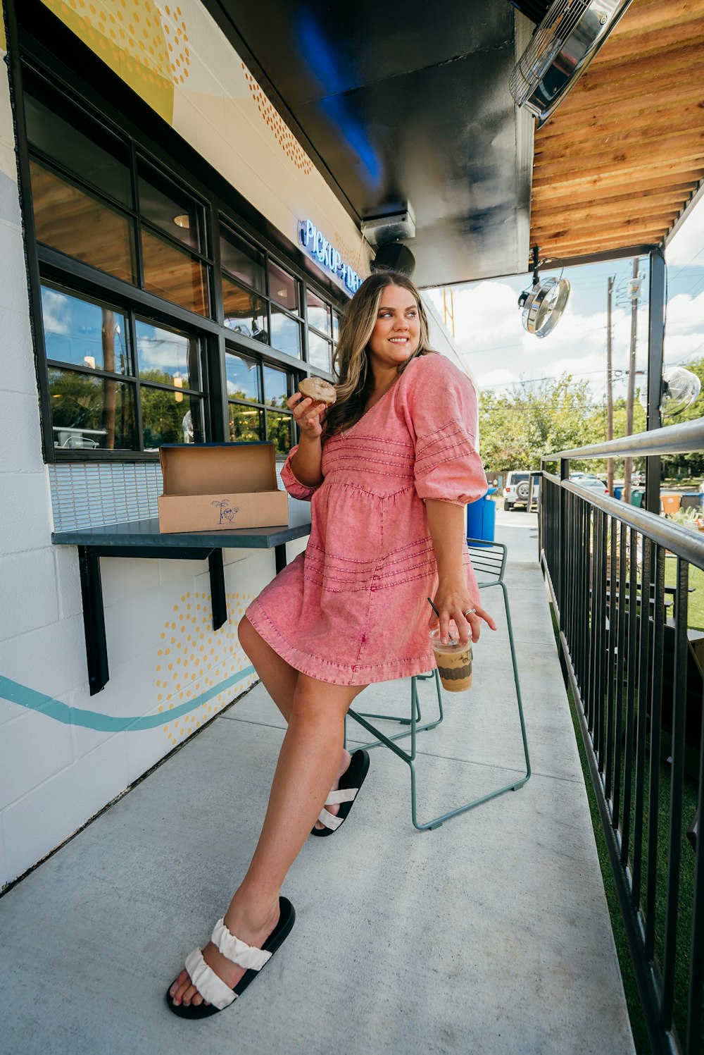 mulher no vestido cor-de-rosa que segura o smartphone