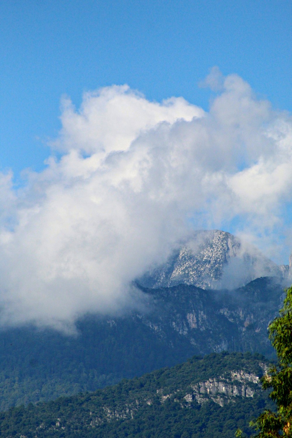 green mountain under white clouds and blue sky during daytime