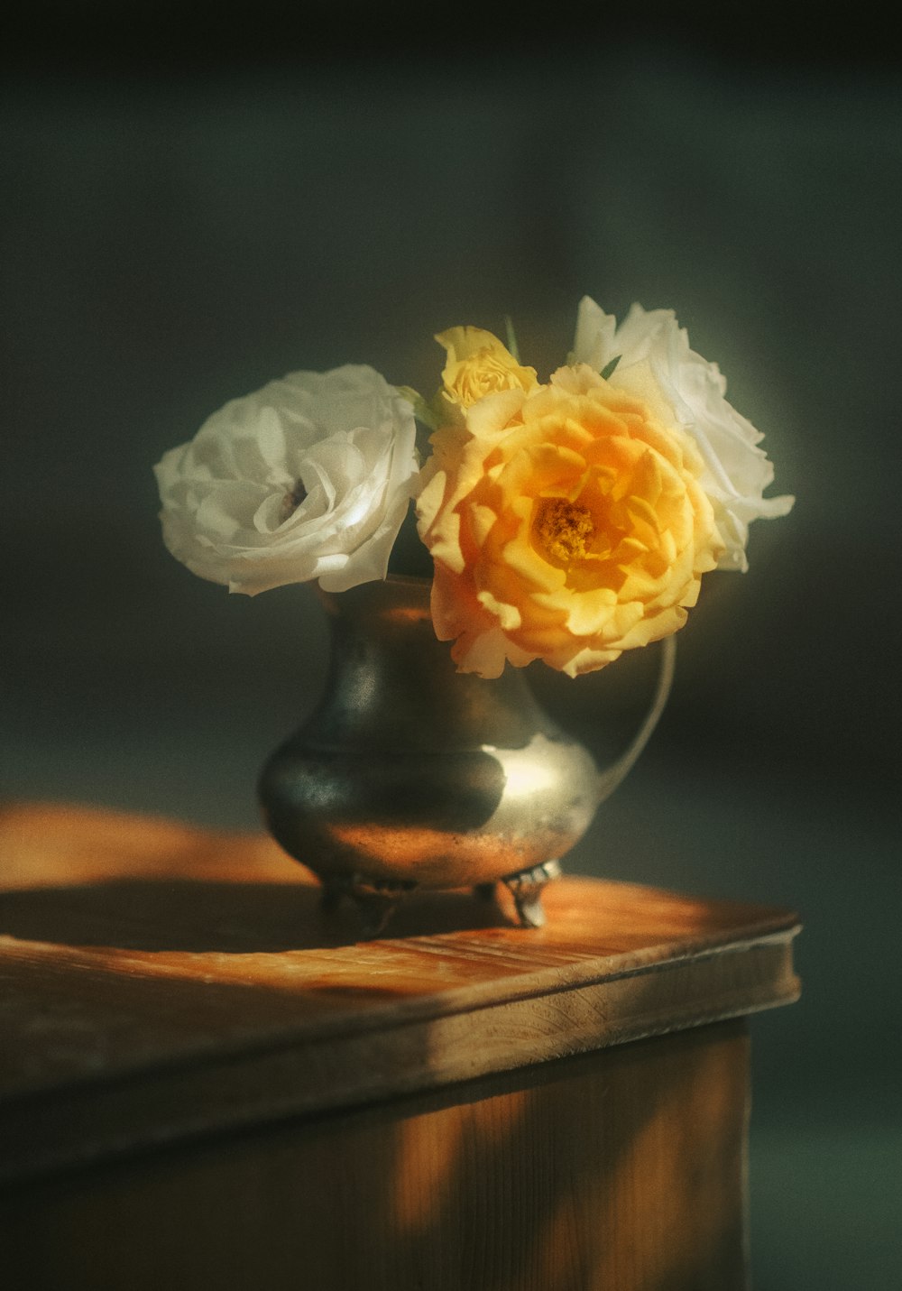 white and yellow flower on black ceramic vase