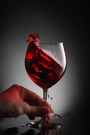 a glass of red wine being poured into it