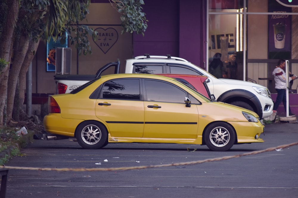 berlina gialla su strada asfaltata grigia durante il giorno