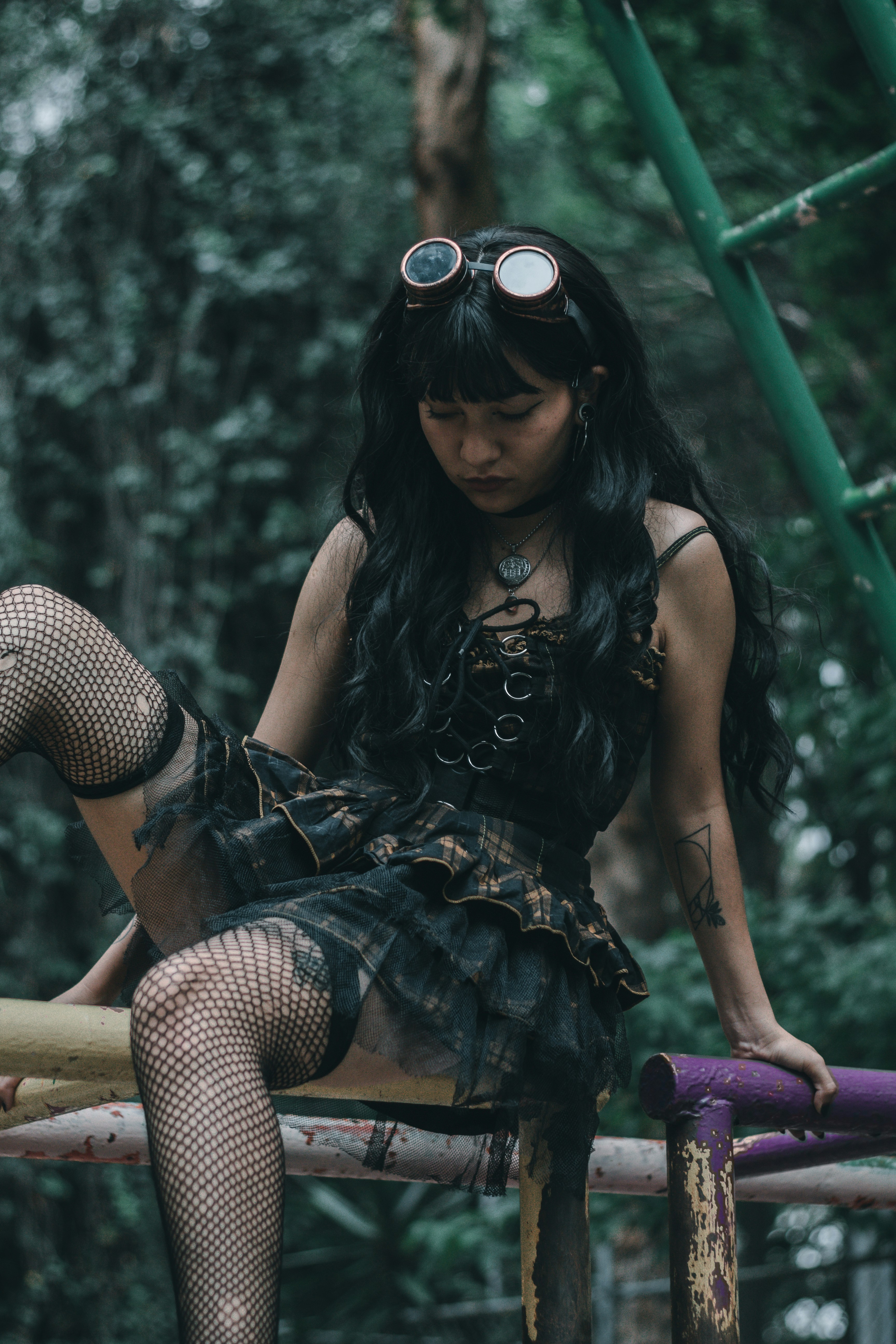 Wanita dengan gaun polkadot hitam dan putih duduk di bangku kayu coklat