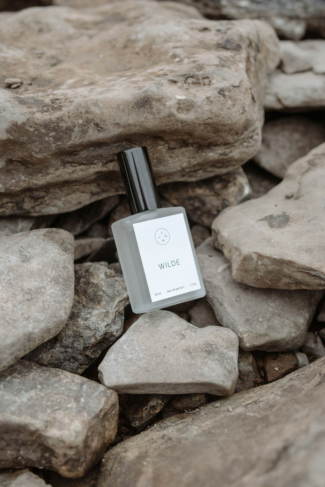 white and black glass bottle on brown rock