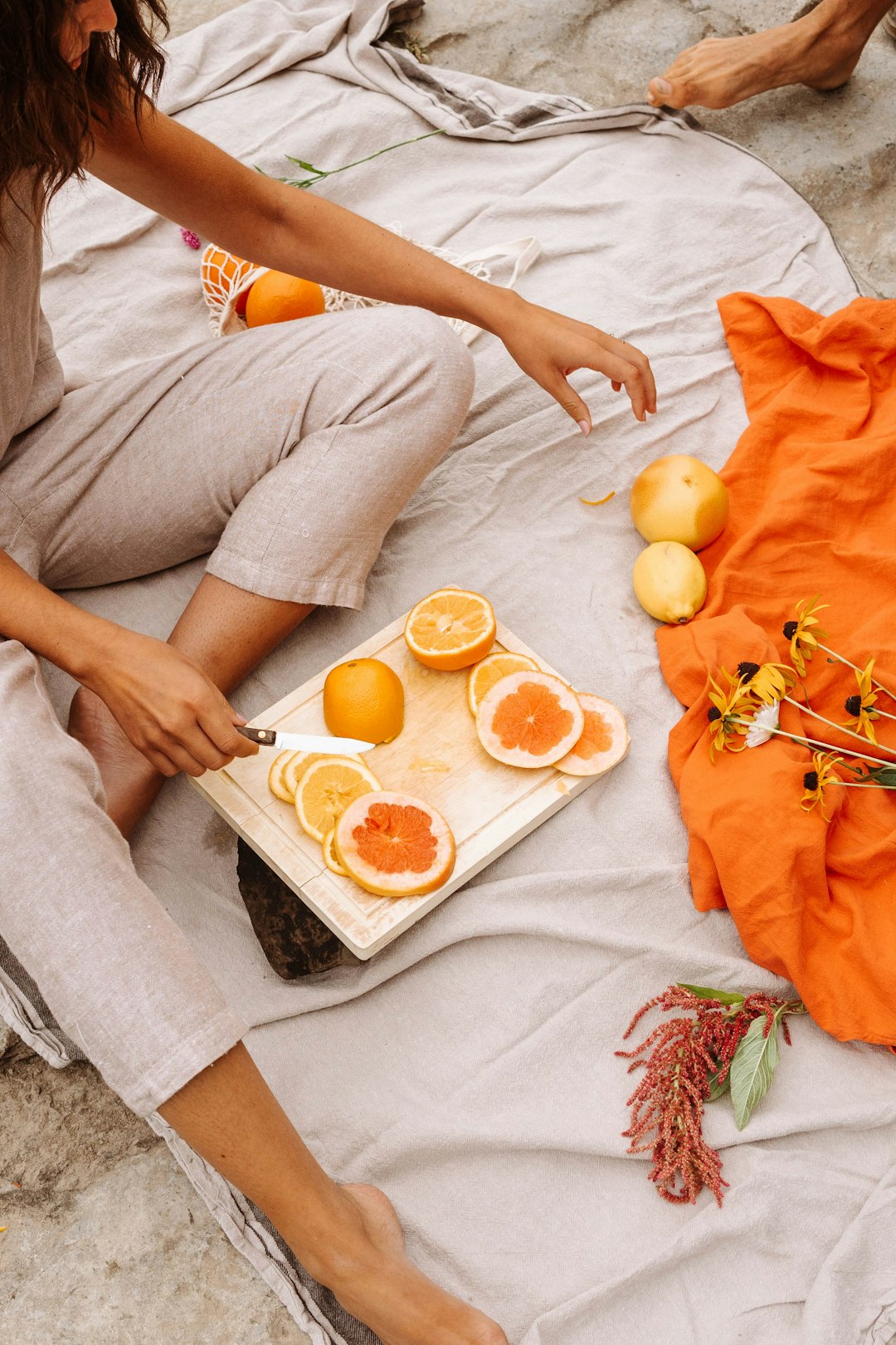 person holding orange fruit on white textile