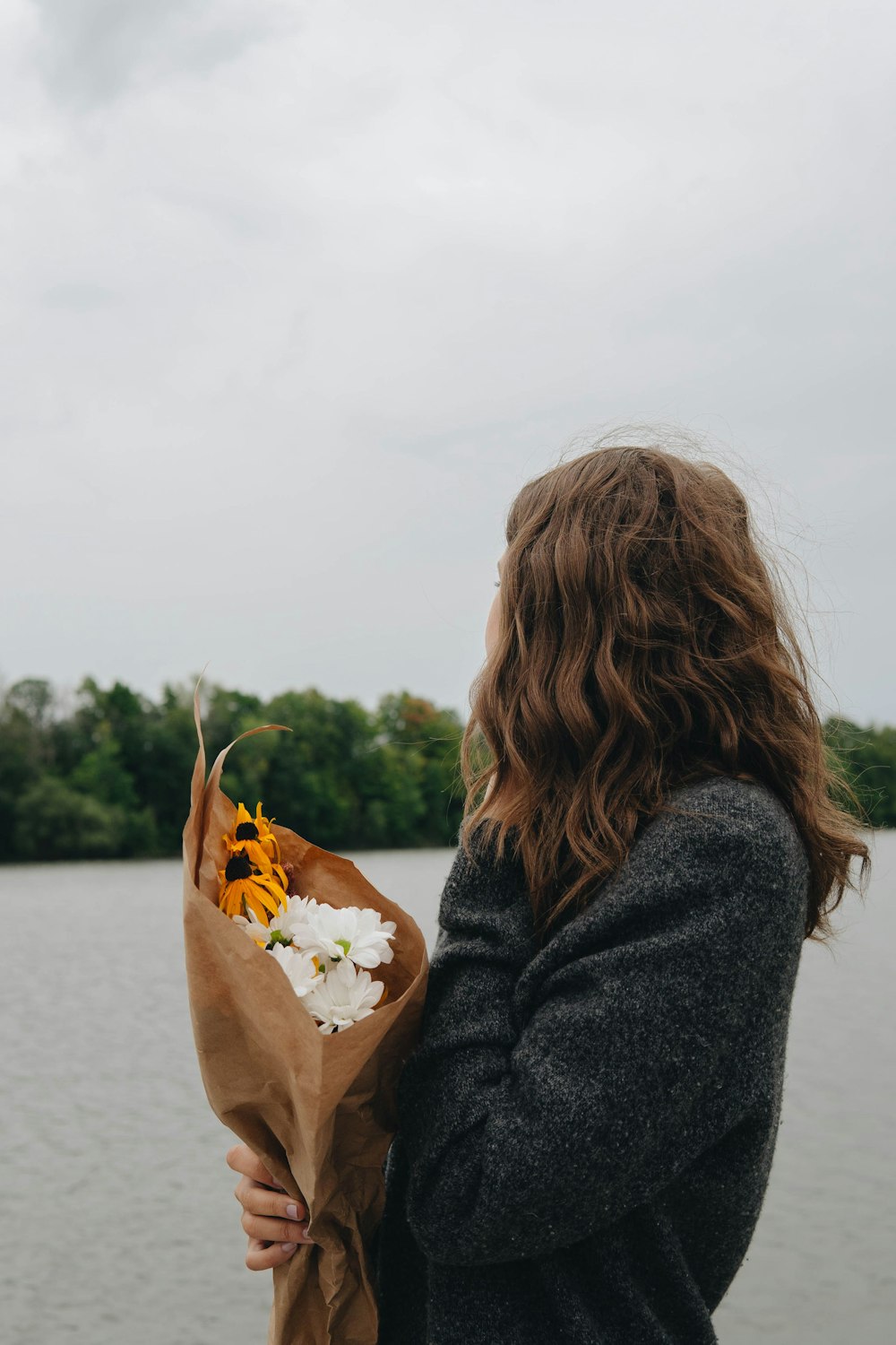 woman in black coat holding yellow leaf