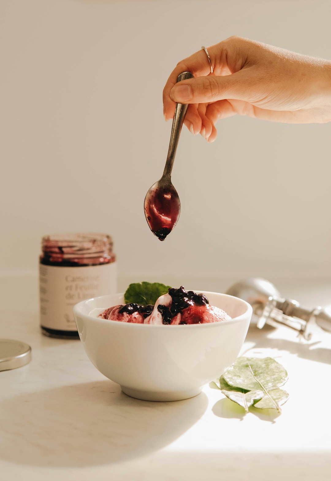 person holding silver spoon and white ceramic bowl