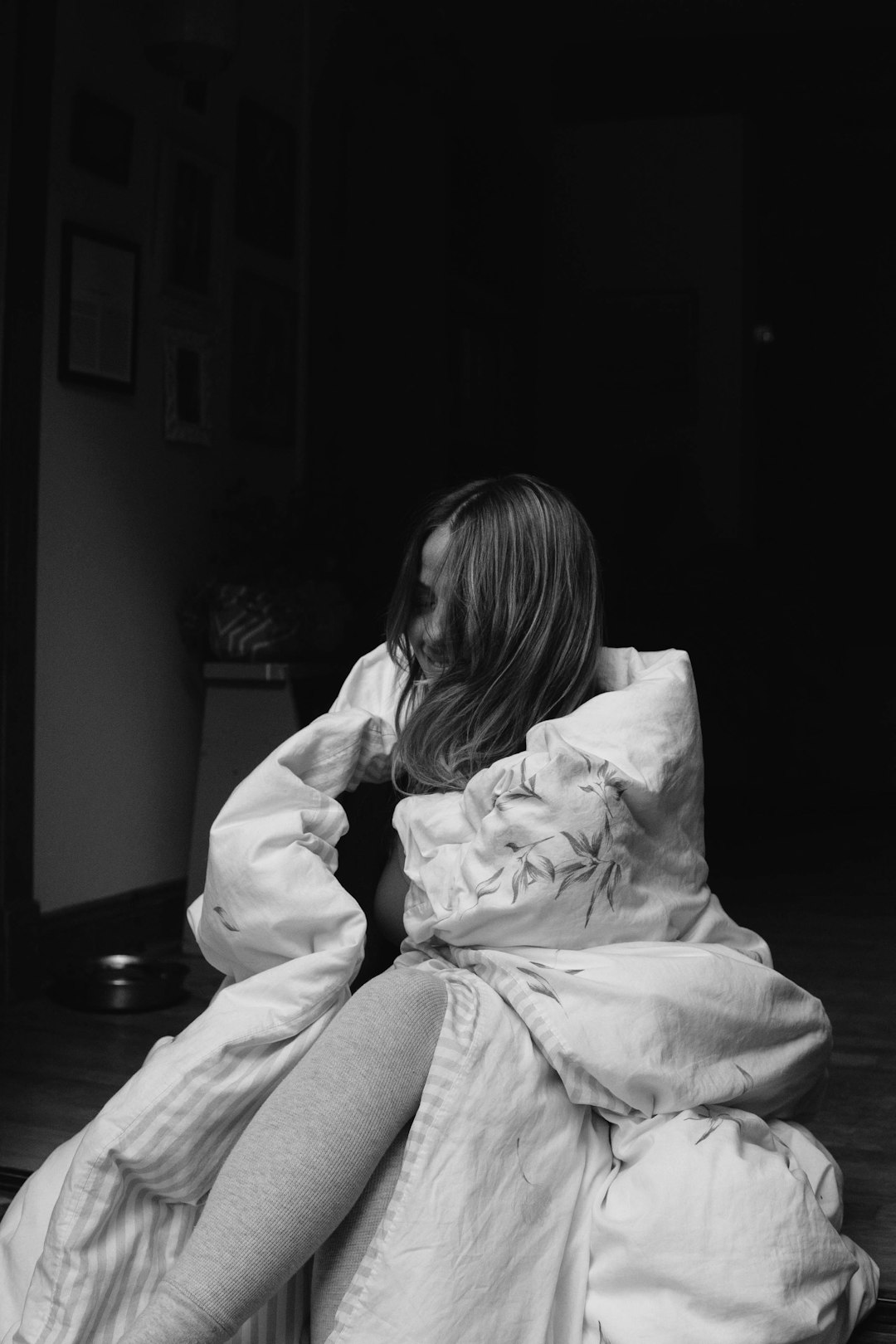 grayscale photo of woman in white hoodie sitting on chair
