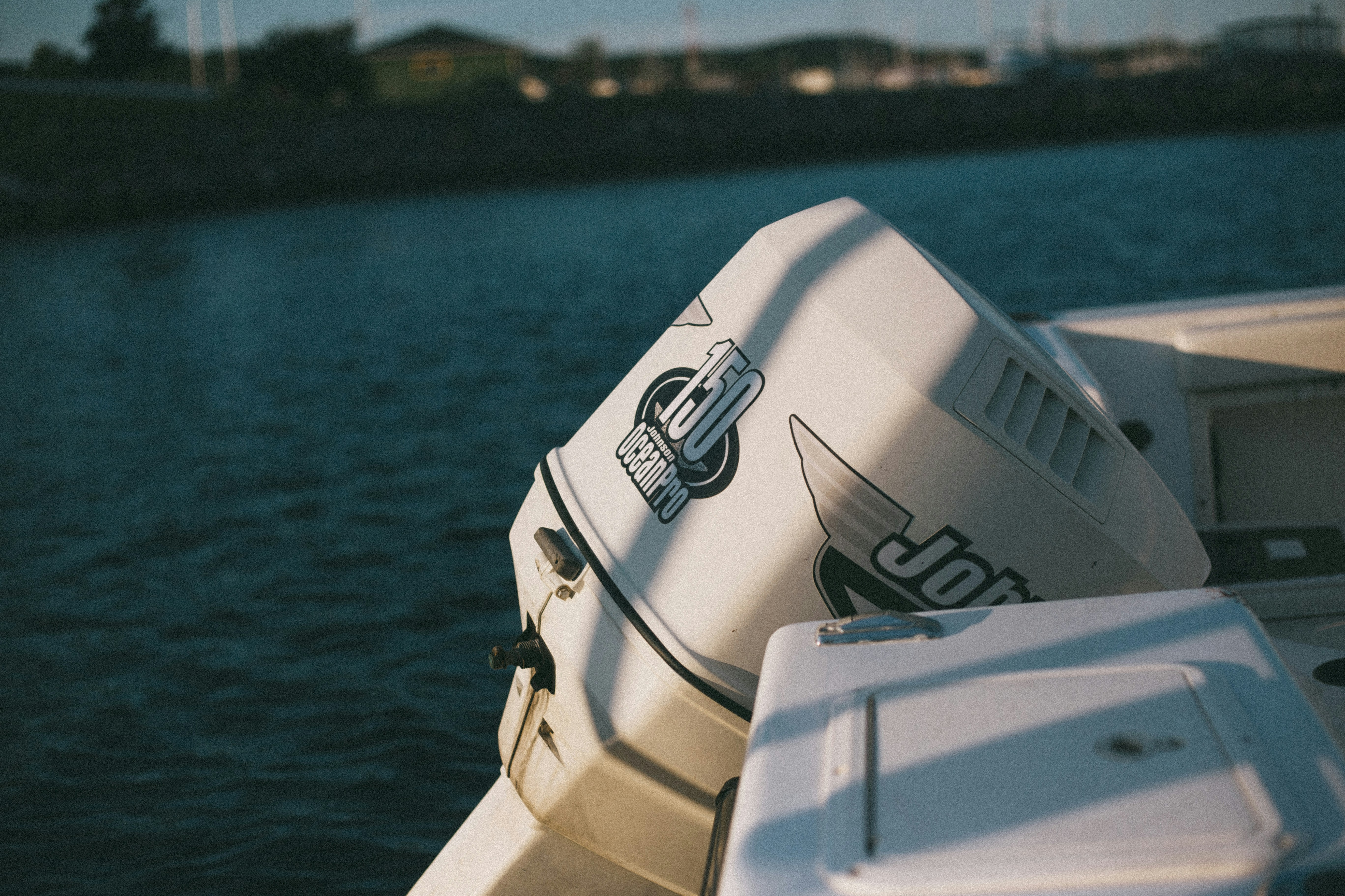 White and black boat on water showing custom boat lettering on hull