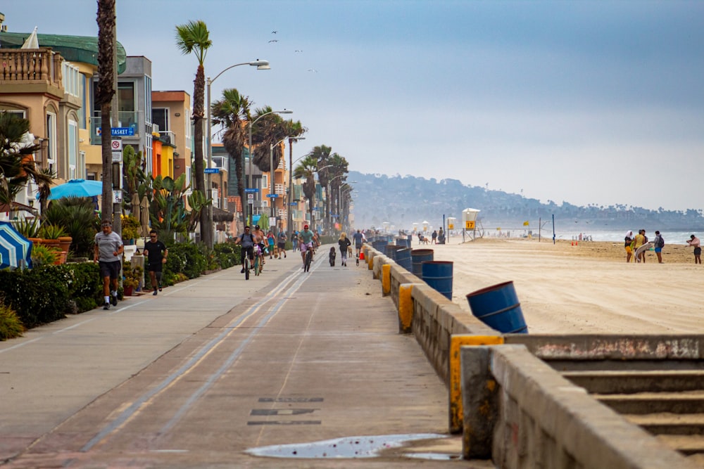 people walking on sidewalk near body of water during daytime